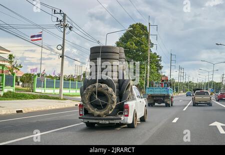 Un pick-up surchargé transportant des pneus en caoutchouc usagés pour le recyclage, pris en Thaïlande. Banque D'Images