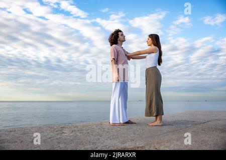 Un jeune couple se touche sur la jetée par la mer Banque D'Images