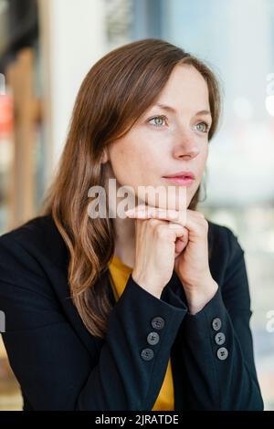Femme d'affaires attentionnés avec les mains sur le menton Banque D'Images