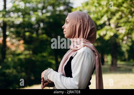 Jeune femme portant le hijab debout dans le parc Banque D'Images