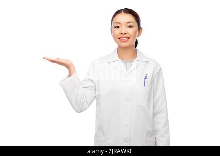 femme asiatique médecin tenant quelque chose à portée de main Banque D'Images