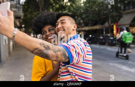 Un jeune homme souriant prend le selfie sur un smartphone avec une femme Banque D'Images