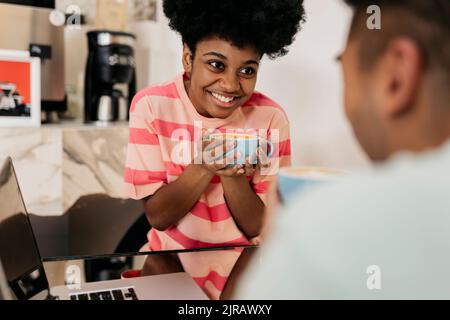 Bonne jeune femme qui apprécie le café avec l'homme au café Banque D'Images