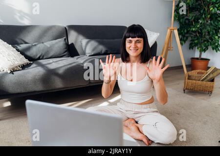 Une femme se portant sur un ordinateur portable lors d'un appel vidéo Banque D'Images