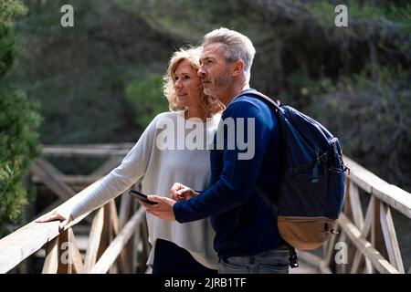 Femme mature avec homme portant un sac à dos debout sur la passerelle Banque D'Images