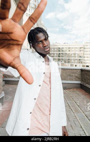 Jeune homme montrant un geste d'arrêt sur la terrasse Banque D'Images