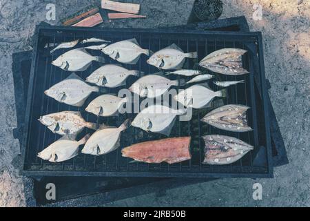 Processus de tabagisme du poisson. Flet fumé. Fumeurs en gros plan. Vue du dessus, mise au point douce Banque D'Images