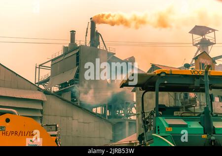 Fumée sombre à la suite de la combustion du charbon dans des fours, qui s'échappe de cheminées dans une usine de ciment à Byrnihat, Meghalaya, en Inde. Banque D'Images
