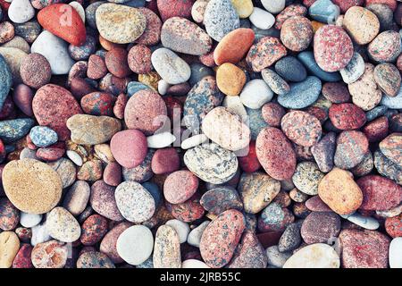 Galets de mer multicolores colorés, arrière-plan de la nature. Petites pierres. Vue de dessus. Banque D'Images