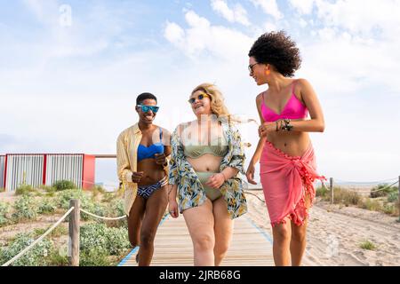 Femmes multiraciales insouciantes qui s'amusent à la plage Banque D'Images