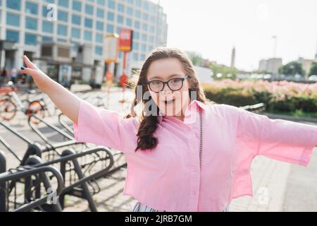 Bonne adolescente avec le syndrome de Down dansant le jour ensoleillé Banque D'Images