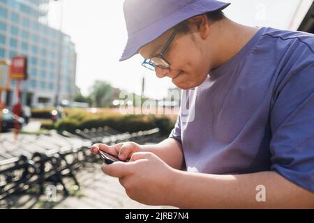 Déterminé adolescent jouant à un jeu vidéo sur téléphone mobile Banque D'Images