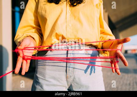 Femme jouant au berceau de chats avec fil sur le sentier Banque D'Images