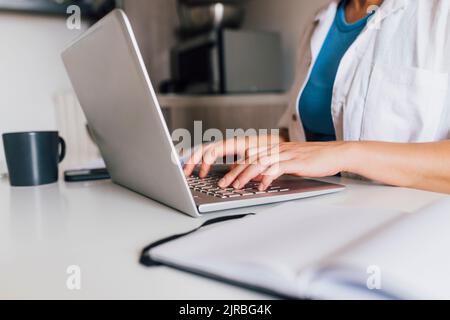 Mains de businesswoman typing on laptop Banque D'Images