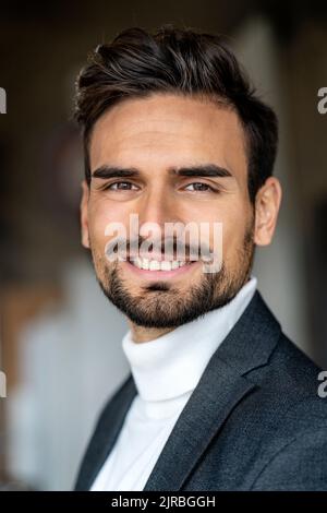 Souriant, beau jeune homme d'affaires portant un col roulé Banque D'Images