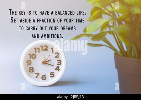 Citation motivationnelle avec réveil blanc et usine en pot - la clé est d'avoir une vie d'équilibre. Prévoyez une fraction de votre temps pour effectuer votre reprise après sinistre Banque D'Images