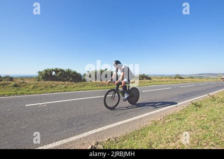 7thAug22 Gower Swansea pays de Galles UK Triathlon Ironman cycliste Lone sur la section plate. Vue latérale se déplaçant de droite à gauche. Banque D'Images