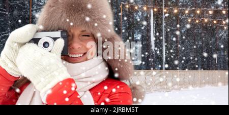 bonne femme avec caméra de cinéma en hiver à la patinoire Banque D'Images