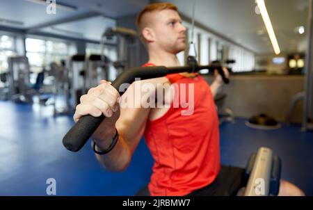 gros plan de l'homme s'exerçant sur la machine à câble dans la salle de gym Banque D'Images