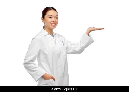 femme asiatique médecin tenant quelque chose à portée de main Banque D'Images