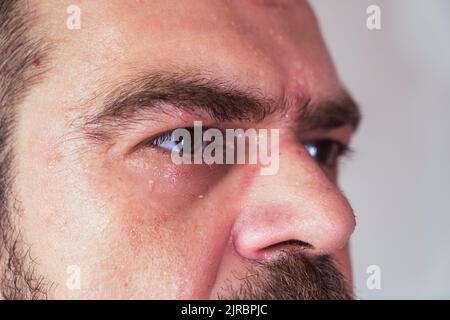 Sueur, barbu, beau homme caucasien regardant vers l'avant sérieusement avec une mise au point sélective, un gros plan extrême. Banque D'Images