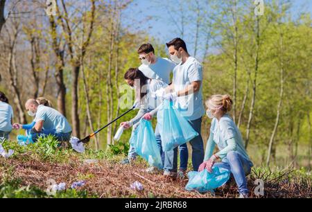 volontaires dans des masques avec nettoyage des ordures au parc Banque D'Images