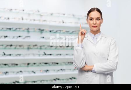 une femme médecin pointe le doigt vers le haut sur le magasin optique Banque D'Images
