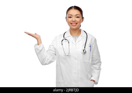 femme asiatique médecin tenant quelque chose à portée de main Banque D'Images