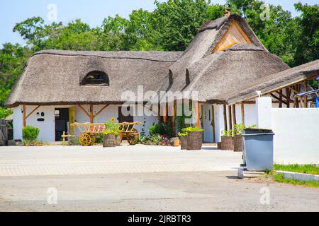 Ancienne maison nationale traditionnelle des Ukrainiens avec un toit de chaume, murs d'argile Mazanka. Ancienne cabane ukrainienne. Ukraine. Chariot à cheval en bois. En bois Banque D'Images
