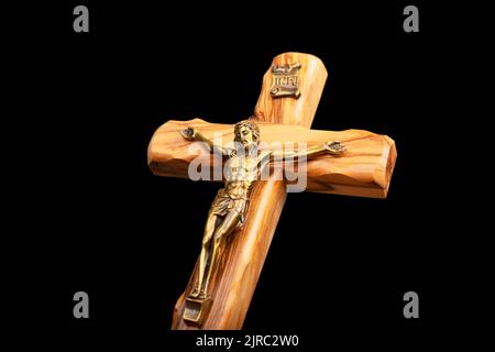 Un crucifix en bois debout sur fond noir. Banque D'Images