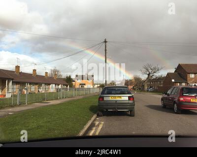 Vue sur les voitures sur une route et double arc-en-ciel sous la pluie de l'après-midi Banque D'Images