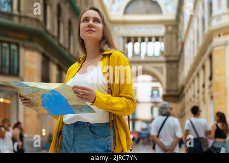 Femme touriste avec des stands de carte dans la Galleria Umberto à Naples. Banque D'Images