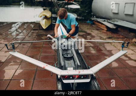 Sportsman Single Scroll man rameur se prépare à la compétition avec le bateau. Banque D'Images