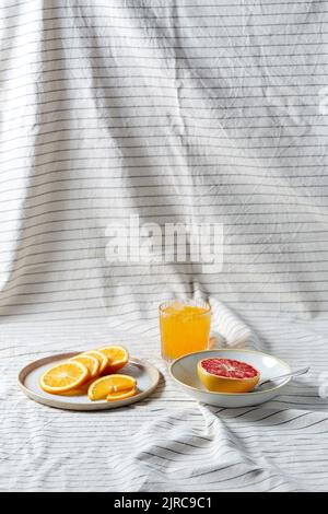 pamplemousse, tranches d'orange et verre de jus Banque D'Images