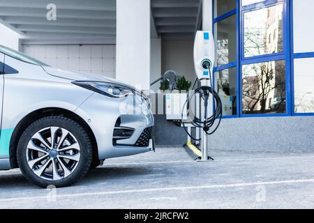 Partie de voiture électrique dans le parking à côté de la station de charge Banque D'Images