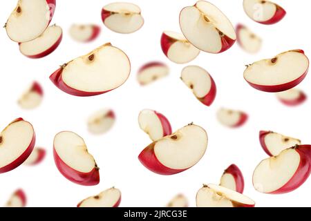 Tranche de pomme rouge tombant isolée sur fond blanc, mise au point sélective Banque D'Images