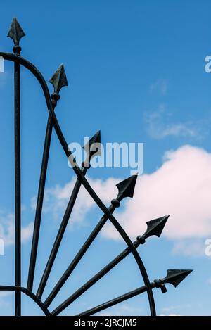 La clôture en fer forgé avec des flèches sur fond bleu ciel à Lisbonne, Portugal Banque D'Images