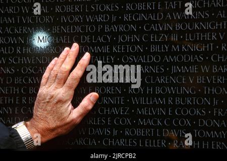 Un parent d'un soldat tué dans la guerre du Vietnam touche le nom gravé dans le mémorial des anciens combattants du Vietnam à Washington, DC. Banque D'Images