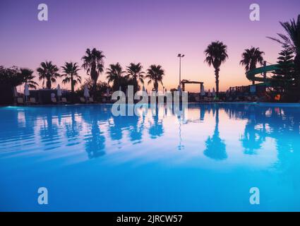 Belle réflexion dans la piscine au coucher du soleil coloré Banque D'Images