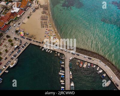 Prise de vue aérienne du port et de la plage de Nea Skioni à Halkidiki, en Grèce, par une journée ensoleillée avec une mer bleu clair Banque D'Images