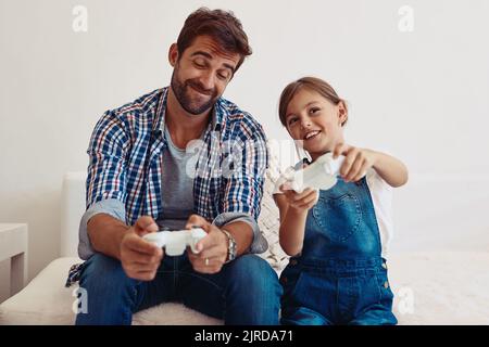 Non, je lui ai donné le seul contrôleur qui fonctionne. Un père et sa fille jouant à des jeux vidéo à la maison. Banque D'Images