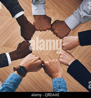 S'unir ensemble comme un seul. Photo en grand angle d'un groupe d'hommes d'affaires non identifiables se joignant entre eux dans une unité. Banque D'Images