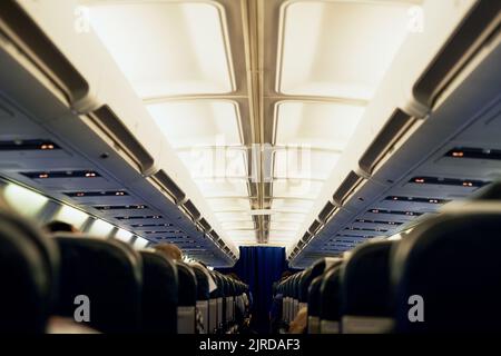 Prêt pour un changement de scène. Vue arrière de passagers non identifiables assis dans une cabine d'avion. Banque D'Images