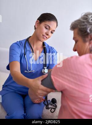 Faire un contrôle de routine. Une infirmière qui vérifie la tension artérielle d'un patient âgé. Banque D'Images