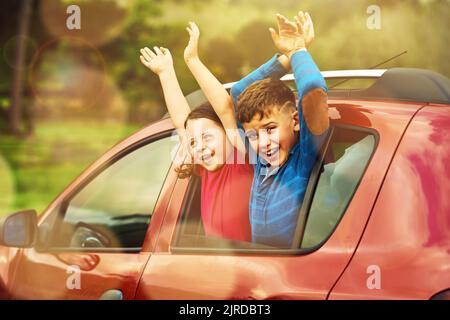 Yay, étaient là. Deux enfants excités se penchent ensemble hors d'une fenêtre de voiture. Banque D'Images