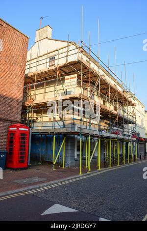 Holywell, Flintshire, Royaume-Uni: 14 août 2022: Locaux de magasin vides avec échafaudage érigés sur la High Street d'une petite ville marchande. Banque D'Images