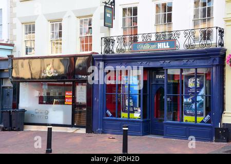 Holywell, Flintshire, Royaume-Uni: 14 août 2022: Les bookmakers William Hill et le bar Gringos Burrito sont voisins sur High Street Banque D'Images