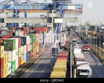 Mannheim, Allemagne. 24th août 2022. Les pompiers refroidissent un conteneur rempli de 200 barils d'hydrosulfite après un déversement de produits chimiques dans le port de Mühlauhafen. Du gaz liquéfié s'est échappé d'un conteneur maritime sur le site de l'usine mardi. Une réaction chimique s'est produite, produisant des irritants et des vapeurs toxiques. Depuis mardi après-midi, une opération à grande échelle est en cours, dans laquelle les pompiers de Mannheim sont soutenus par la police de l'eau, l'organisation de secours technique et d'autres. (Meilleure qualité possible) Credit: Dieter Leder/dpa/Alay Live News Banque D'Images