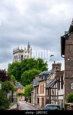 LE BEC-HELLOUIN, FRANCE - 26th MAI 2022 : vue sur une rue avec de vieilles maisons à colombages et la tour de l'abbaye. Banque D'Images