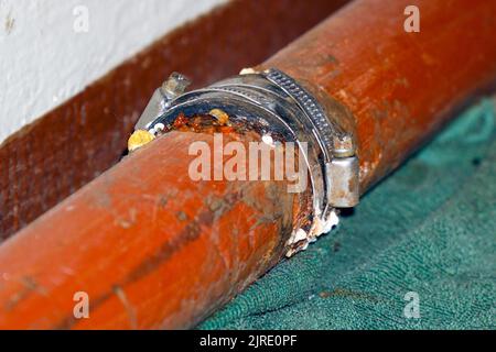 Fixer le raccord sur un tuyau d'eau qui fuit. Mise au point sélective Banque D'Images